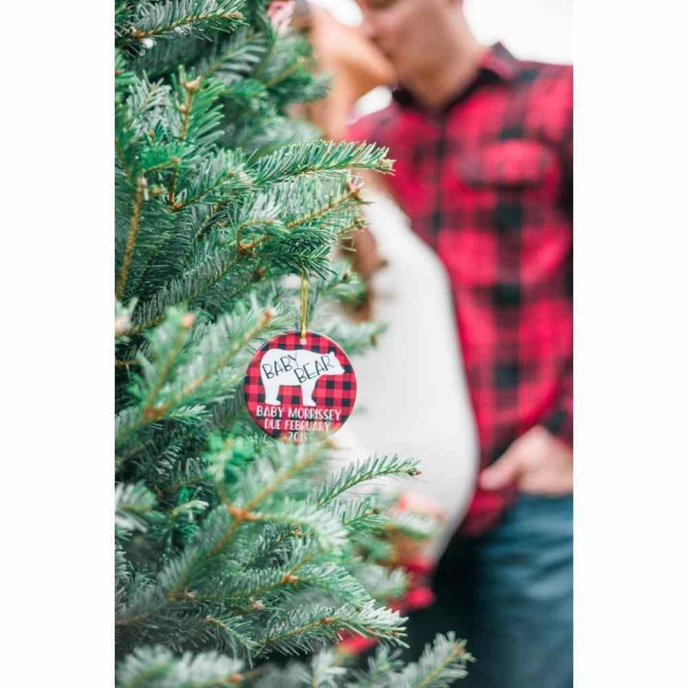 Couple enceinte devant le fond de l'arbre de Noël